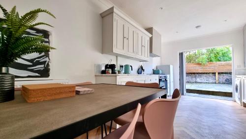 a kitchen with a large wooden table and chairs at Moorland House by Switchback Stays in Cardiff