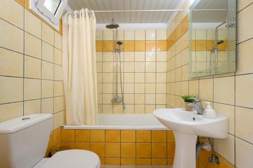 uma casa de banho com um WC, um lavatório e uma banheira em Kerkyra Island Hotel em Mesongi