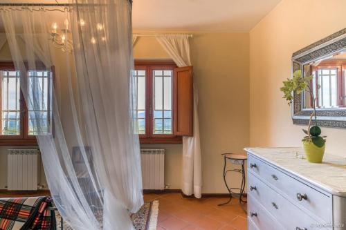 Habitación con vestidor, espejo y ventanas. en Villa Malula a classy house in the countryside, en Capannori