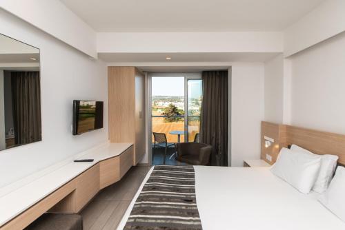 a hotel room with a bed and a view at Evalena Beach Hotel in Protaras