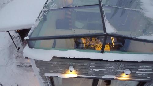 a truck covered in snow with people sitting in it at Levi Secret Igloo Revontuli in Levi