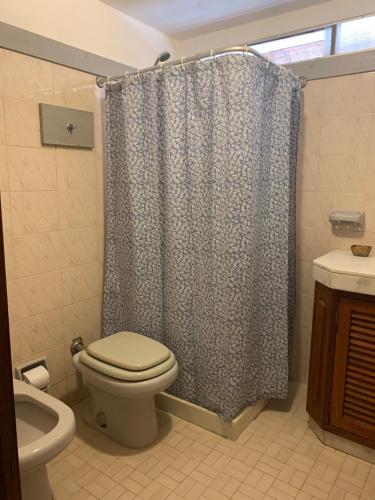 ein Badezimmer mit Toilette und Duschvorhang in der Unterkunft CASA MARÍTIMA EN PORTEZUELO, MALDONADO, URUGUAY in Punta del Este