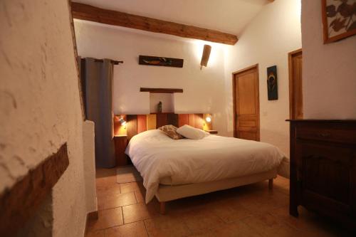 a bedroom with a white bed in a room at Le Priolat des Anges aux portes des gorges du Verdon in Trigance