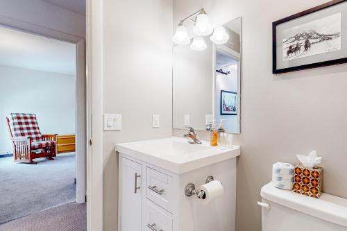 a white bathroom with a sink and a mirror at Sugarloaf Mountain Treasure in Carrabassett
