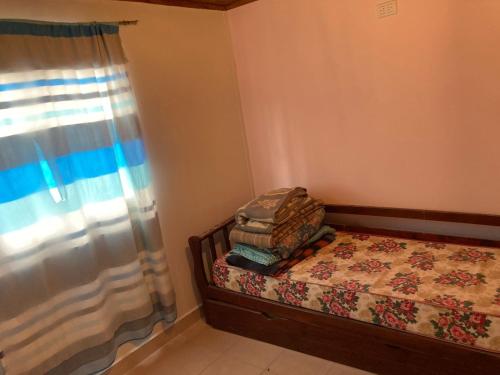 a small bedroom with a bed and a window at Cabañas de Dario, Divino Tesoro in Alumbrera