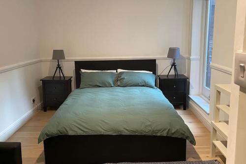 een slaapkamer met een groot bed met 2 nachtkastjes bij the flat with the heart in Londen