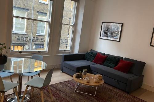 een woonkamer met een bank en een tafel bij the flat with the heart in Londen