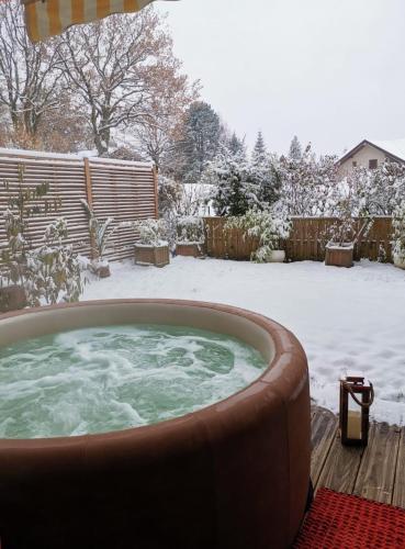 a hot tub in a yard covered in snow at ** Nouveau ** Le Jardin De La Plage - Appartement avec extérieur in Saint-Jorioz