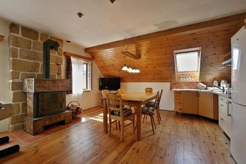 a kitchen and dining room with a table and a fireplace at Miniresort AMULET in Hrubá Skála