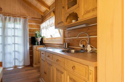 a kitchen with wooden cabinets and a sink and a window at Miniresort AMULET in Hrubá Skála