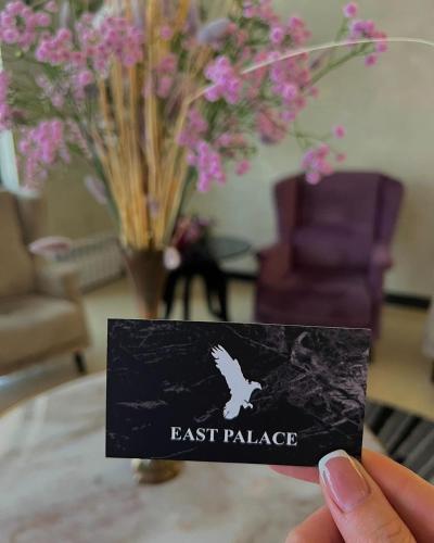 a person holding a card that says east palace at East Palace Hotel in Almaty