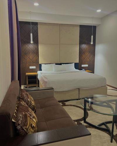 a hotel room with a bed and a couch at East Palace Hotel in Almaty