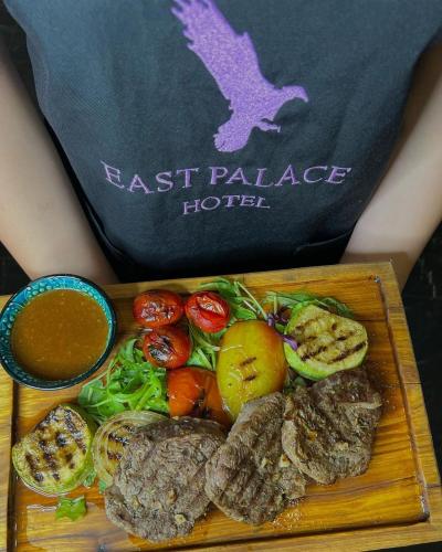 a tray of food with meat and vegetables on a table at East Palace Hotel in Almaty