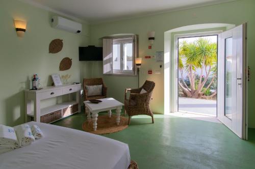 a bedroom with a bed and a door to a patio at Change The World - Herdade Monte do Peral in Montes Juntos