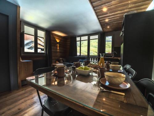 d'une table en bois avec des bols de nourriture. dans l'établissement Charmant appartement ski aux pieds avec balcon à Tignes Le Val Claret - FR-1-502-358, à Tignes