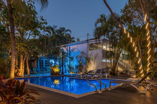 a house with a swimming pool and palm trees at Papa's Hideaway in Key West