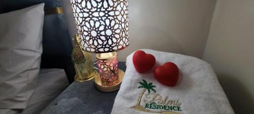 two hearts on a towel on a table with a lamp at Traditional place with a Special Moroccan touch I Fibre Internet Up to 100 Mbps I PALMS Residence in Er Rachidia