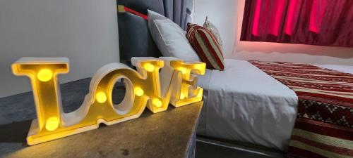 una habitación de hotel con un cartel que dice amor en una cama en Traditional place with a Special Moroccan touch I Fibre Internet Up to 100 Mbps I PALMS Residence en Er-Rachidía
