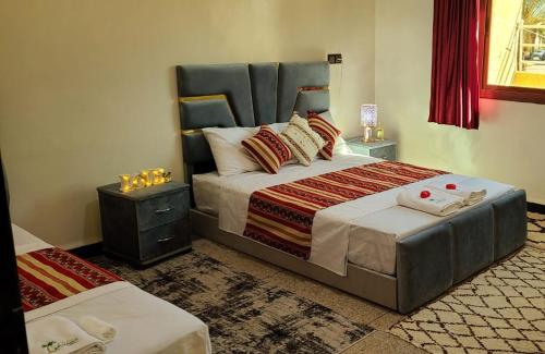 a bedroom with a large bed with two tables at Traditional place with a Special Moroccan touch I Fibre Internet Up to 100 Mbps I PALMS Residence in Er Rachidia