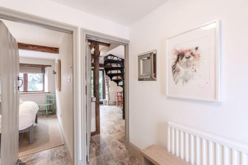 a hallway with a staircase in a house at Otters Abode in Blockley