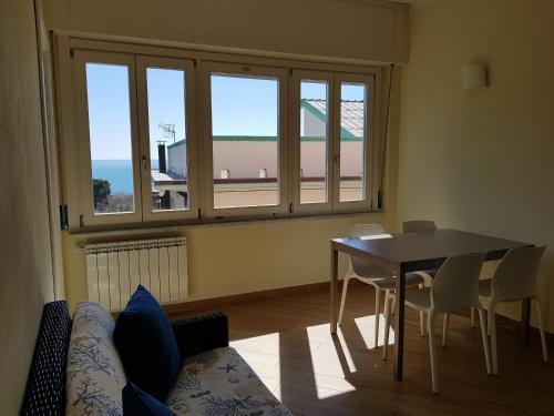 a living room with a table and chairs and a window at Ca Messina in Monterosso al Mare