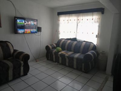 uma sala de estar com um sofá e uma televisão em Linas home em Toluca