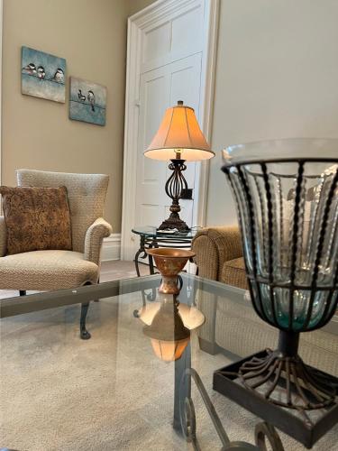 a living room with a glass table and a lamp at Extended Stays by Lee House Inn in Maysville