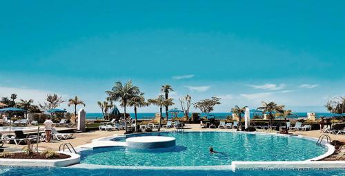 uma piscina num resort com pessoas a nadar nela em Residencial La Quinta Park Suites em Santa Úrsula