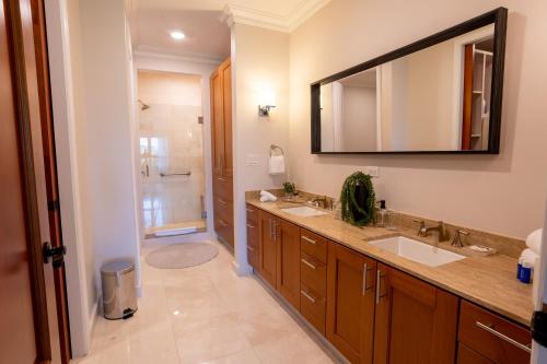 ein Badezimmer mit zwei Waschbecken und einem großen Spiegel in der Unterkunft The Country Club Residences at Grand Reserve in Rio Grande