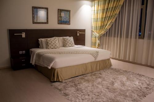 a bedroom with a large bed and a rug at Butterfly Residence in Manama