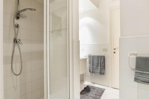 uma casa de banho branca com um chuveiro e um lavatório. em Flaminia71 em Roma