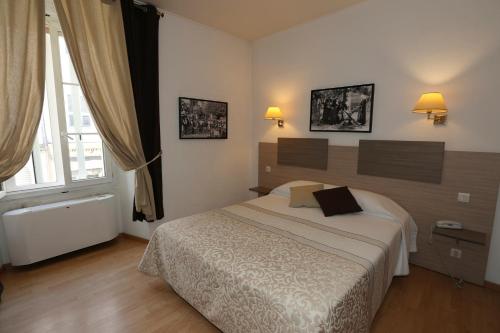 a bedroom with a bed and a large window at Hôtel du Nord in Corte