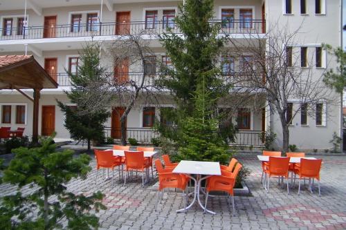 a group of tables and chairs in front of a building at Hotel Aşıkoğlu in Bogazkale