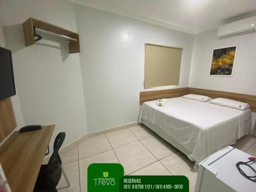 a small room with a bed and a mirror at Hotel Trevo Caruaru in Caruaru