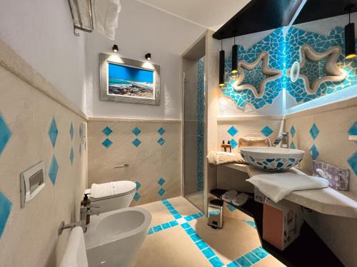 a bathroom with a toilet and a sink at Suite Villa Domos in Porto Pino