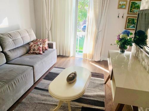 a living room with a couch and a table at Aconchegante casa em Bento Gonçalves in Bento Gonçalves