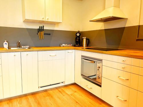 a kitchen with white cabinets and a stove top oven at B&B de Muldermolen in Schinnen