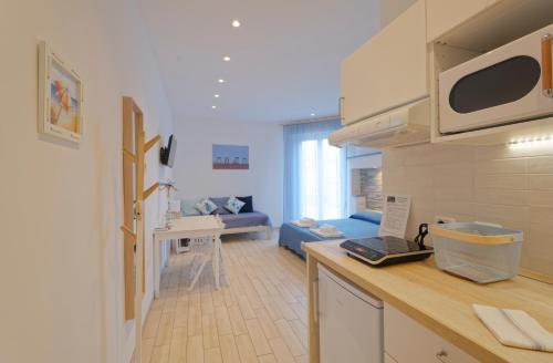 uma cozinha e sala de estar com um sofá num quarto em Porto d'aMare - Rooms em Porto Recanati