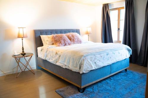 Schlafzimmer mit einem Bett mit blauem Kopfteil in der Unterkunft Traumwohnung auf kleiner Pferdefarm in Thun