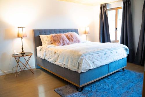 a bedroom with a bed with a blue headboard at Traumwohnung auf kleiner Pferdefarm in Thun