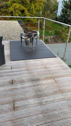 une terrasse en bois avec une chaise au-dessus dans l'établissement Ferienhaus Rolf, 