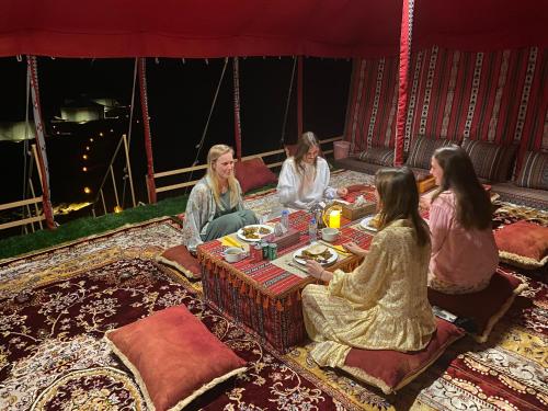 a group of women sitting around a table at Desert waves camp in Bidiyah
