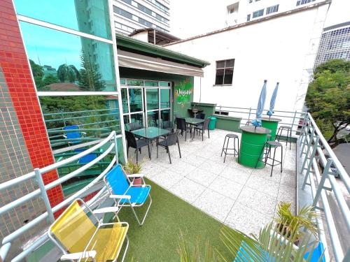 ein Balkon mit Stühlen und Tischen an einem Gebäude in der Unterkunft Br Hostel in Belo Horizonte