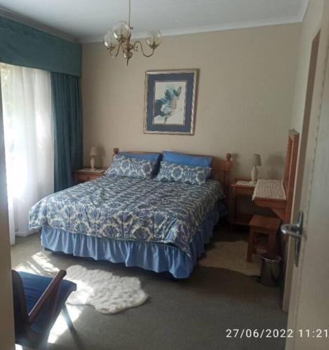 a bedroom with a bed with a blue comforter at CHEZ BRUNO in Pretoria
