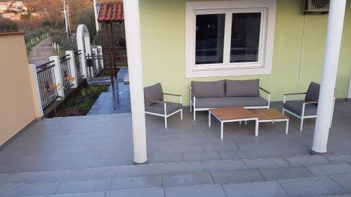 un patio con 2 sedie e una panchina su una casa di Villa Aberdeen a Tivat