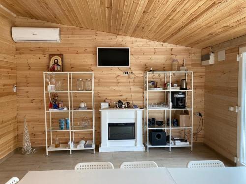Habitación con pared de madera, TV y estanterías. en COMPLEX TURISTIC AVENTURA CAMP, en Eşelniţa