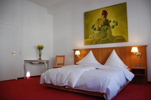 a bedroom with a large bed with a painting on the wall at Hotel Mohren Post in Wangen im Allgäu
