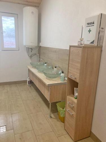 a bathroom with two sinks on a counter at COMPLEX TURISTIC Gradina de corzi si Aventura Eselnita in Eşelniţa