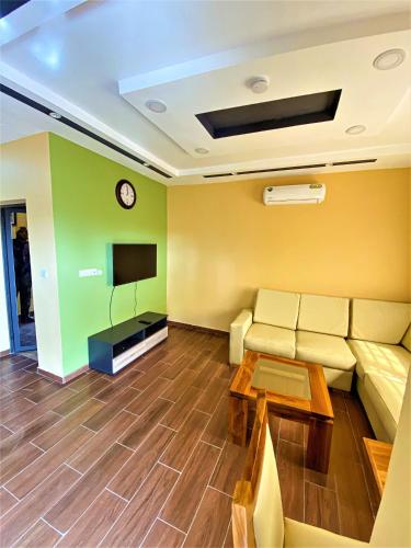 a living room with a couch and a tv at RÉSIDENCE BELLEVUE SITO AIPORT- Lomé in Lomé