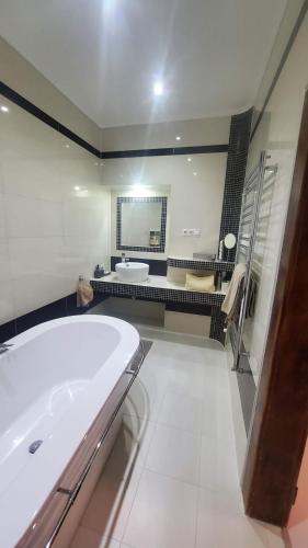 a large bathroom with a tub and a sink at Apartmán Julie in Loket